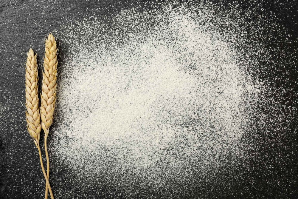 Рассыпанная мука на черном фоне