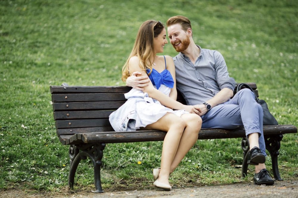 Парень и девушка сидят на скамейке