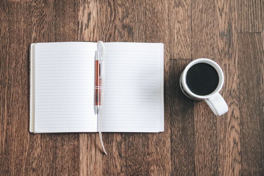 Открытый блокнот с ручкой