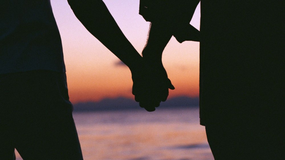 Руки влюбленных на закате