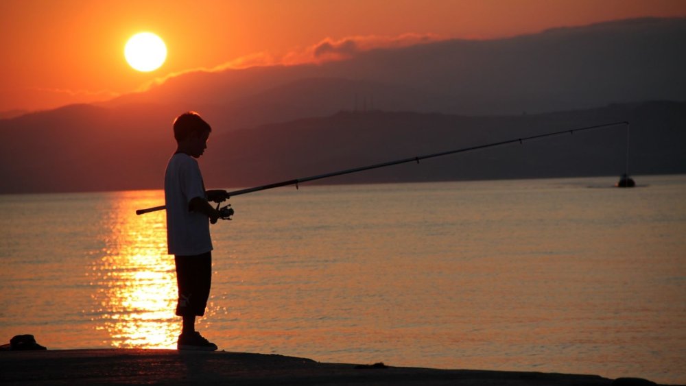 Рыбак в лодке на закате