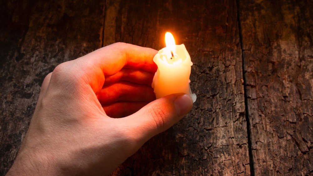 Зажженная свеча в руках