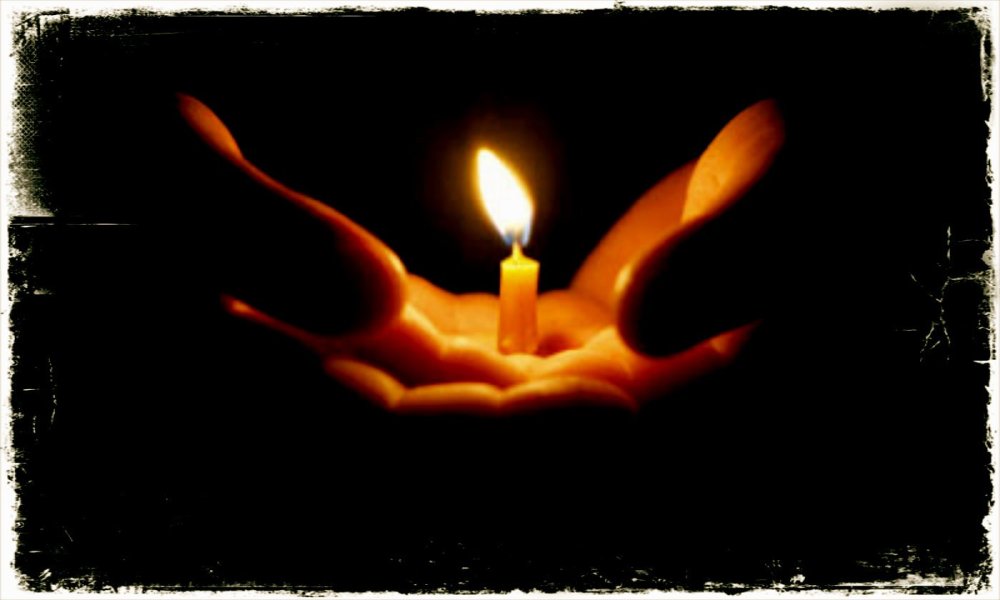 Свечка в руках в темноте