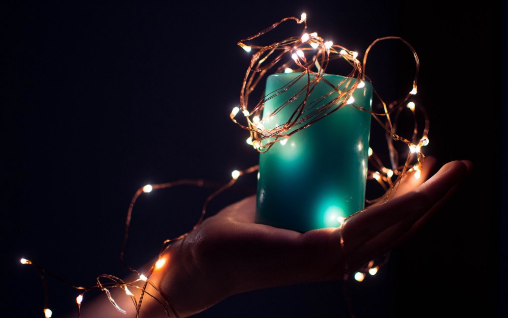 Человек держит в руках свечу