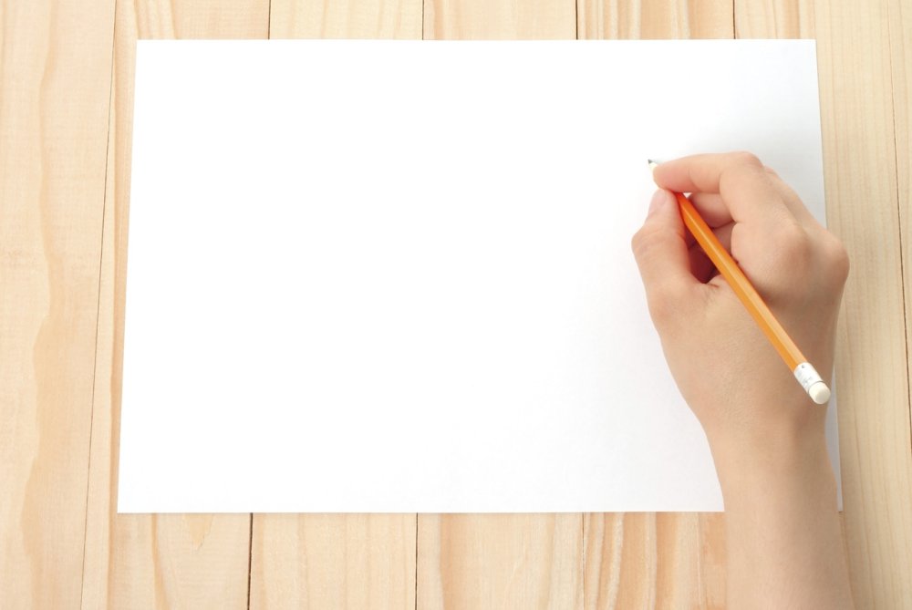 Рука с ручкой и листом бумаги