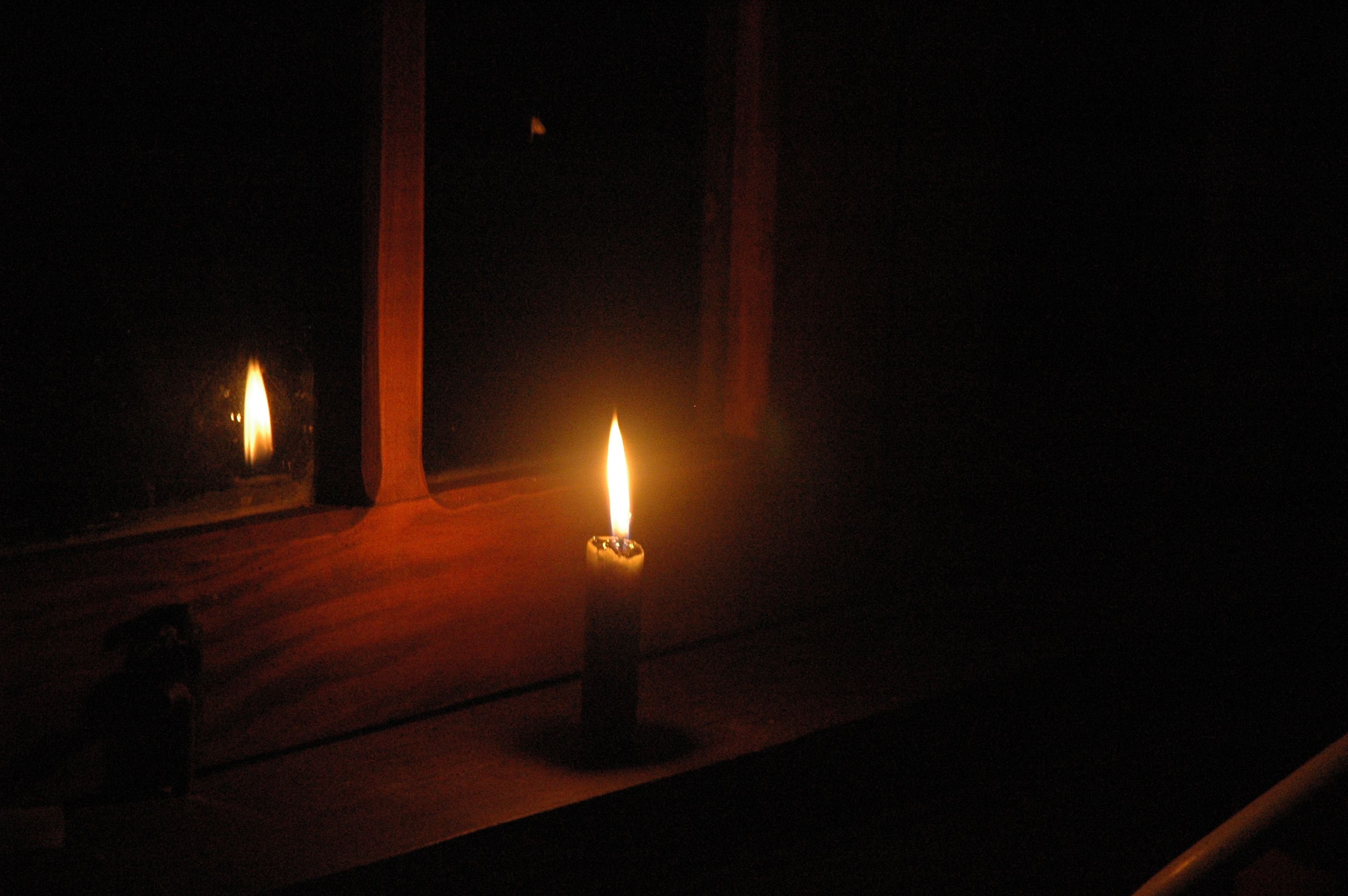 Одиноко свечи горят. Свеча в темноте. Свеча в окне. Темная комната со свечами. Горящая свеча.