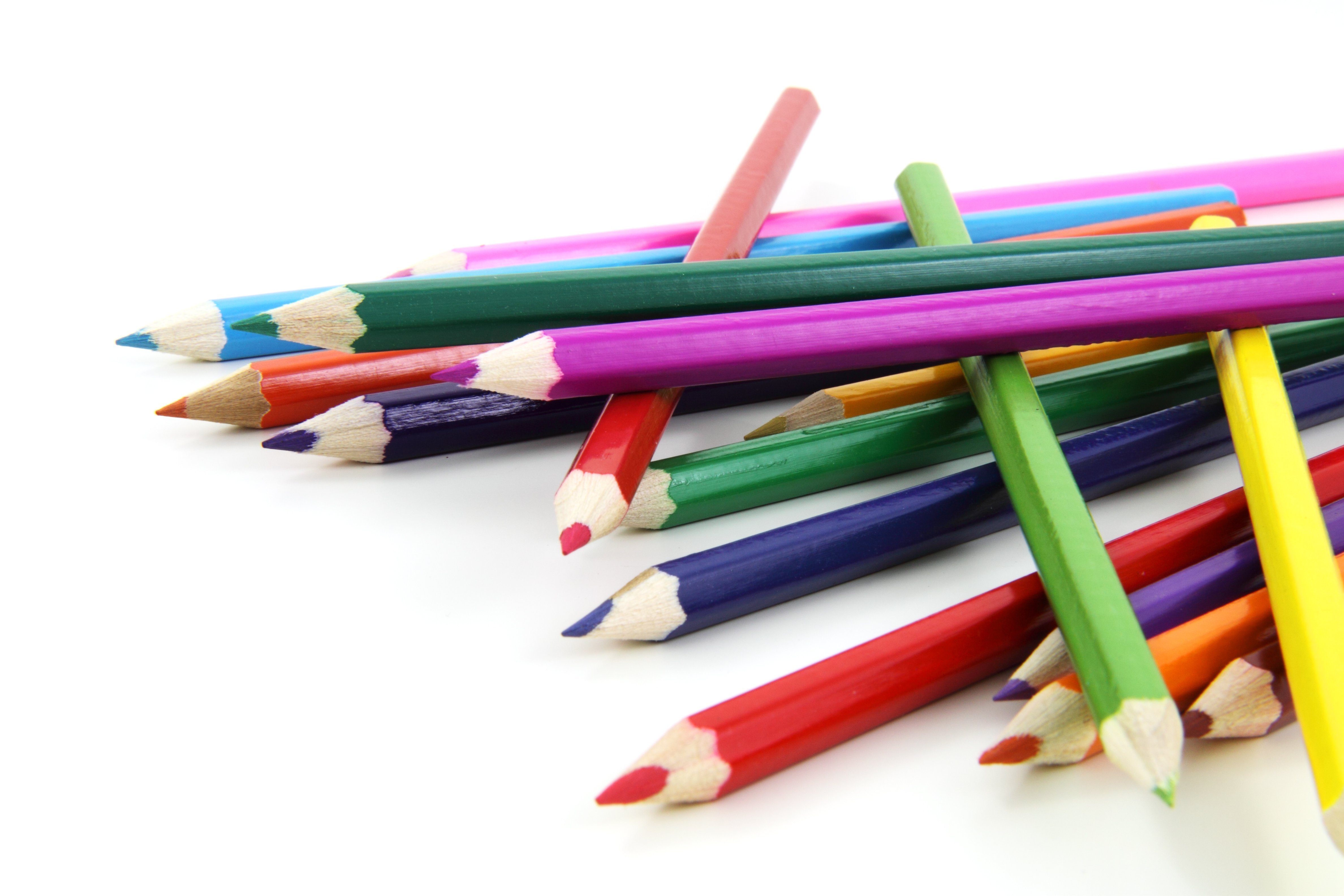 На столе лежат две коробки с карандашами. Карандаши цветные. Цветные карандаши на белом фоне. Цветные карандаши разбросаны. Ручки и карандаши.