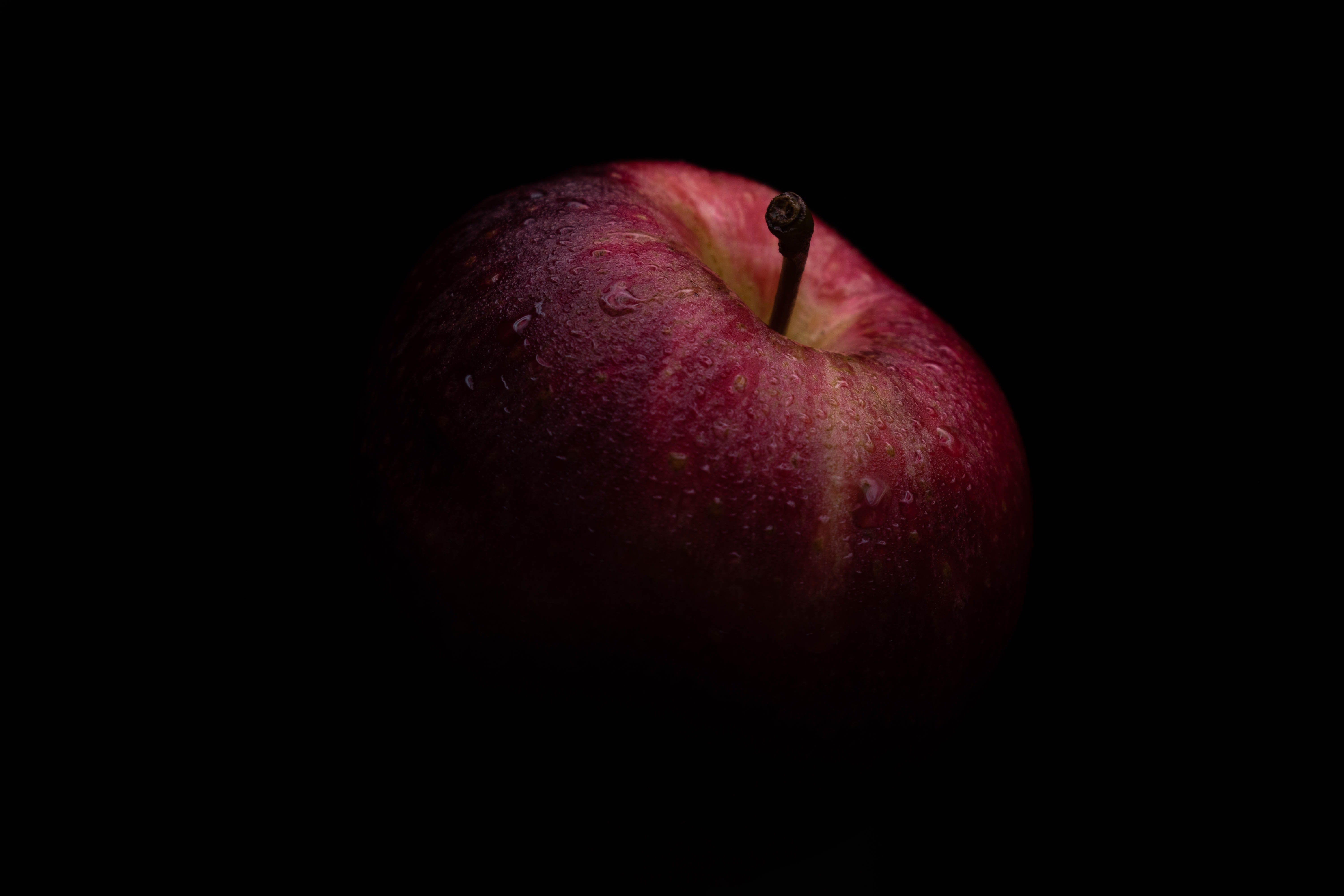Яблоко на черном фоне. Яблоко на темном фоне. Текстура яблока. Красное яблоко на черном фоне. Фрукты на черном фоне.