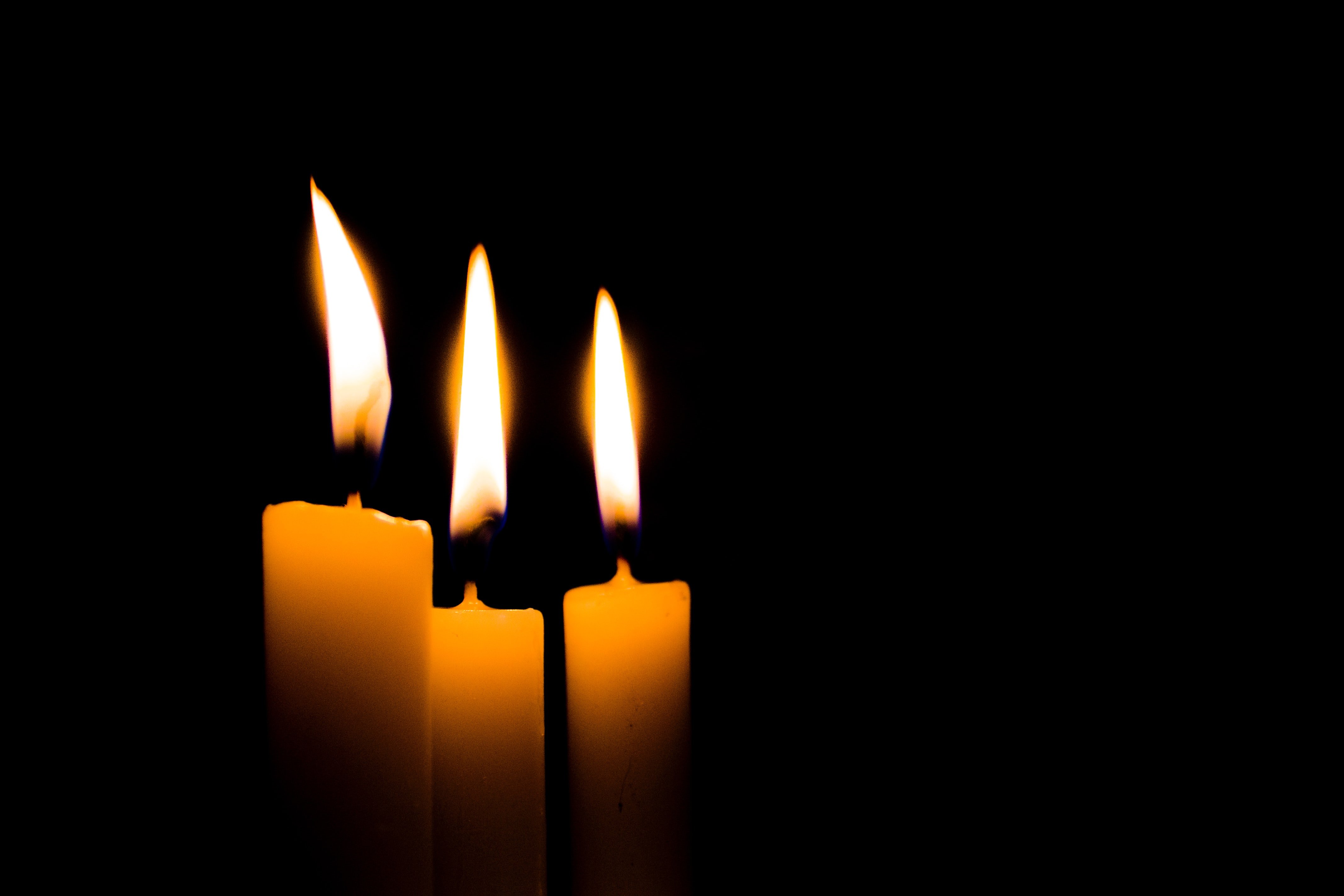 Горят три свечи. Свеча на черном фоне. Огонь свечи. Горящая свеча. Свеча на темном фоне.