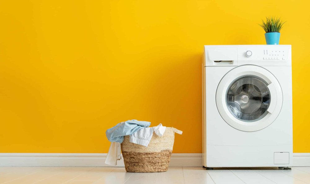 Стиральная машина на фоне стены