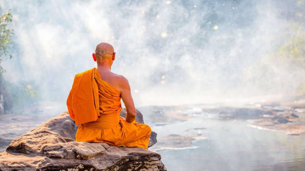 Монах медитирует на скале