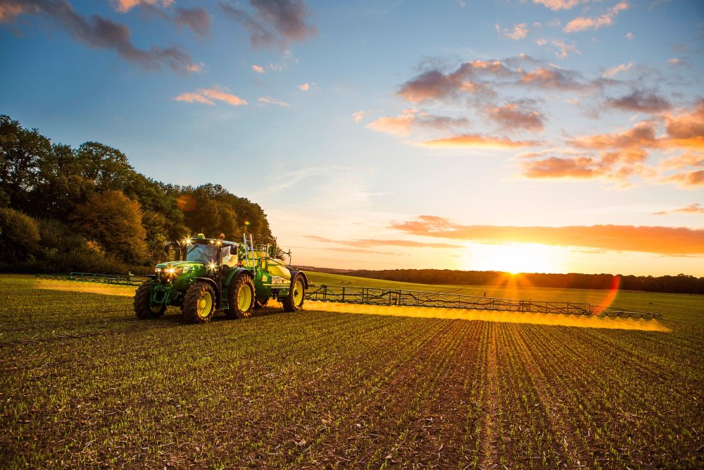 Трактор John Deere на зеленом поле