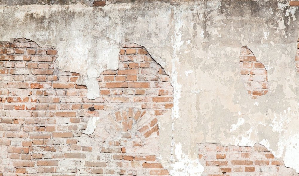 Старая штукатурка на кирпичной стене