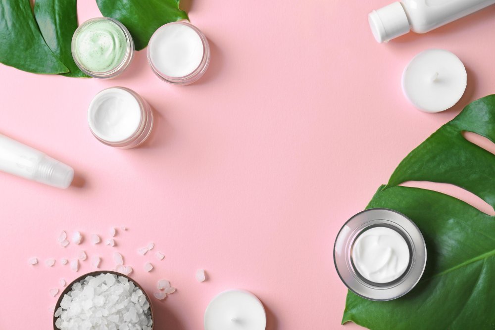 Косметические крема на розовом фоне