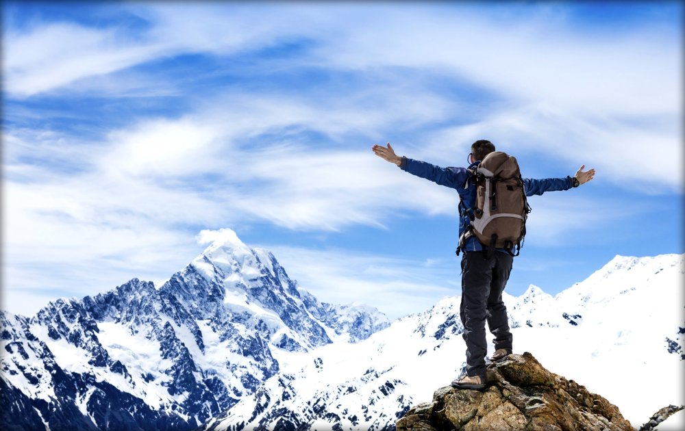 Мужчина на вершине горы снег