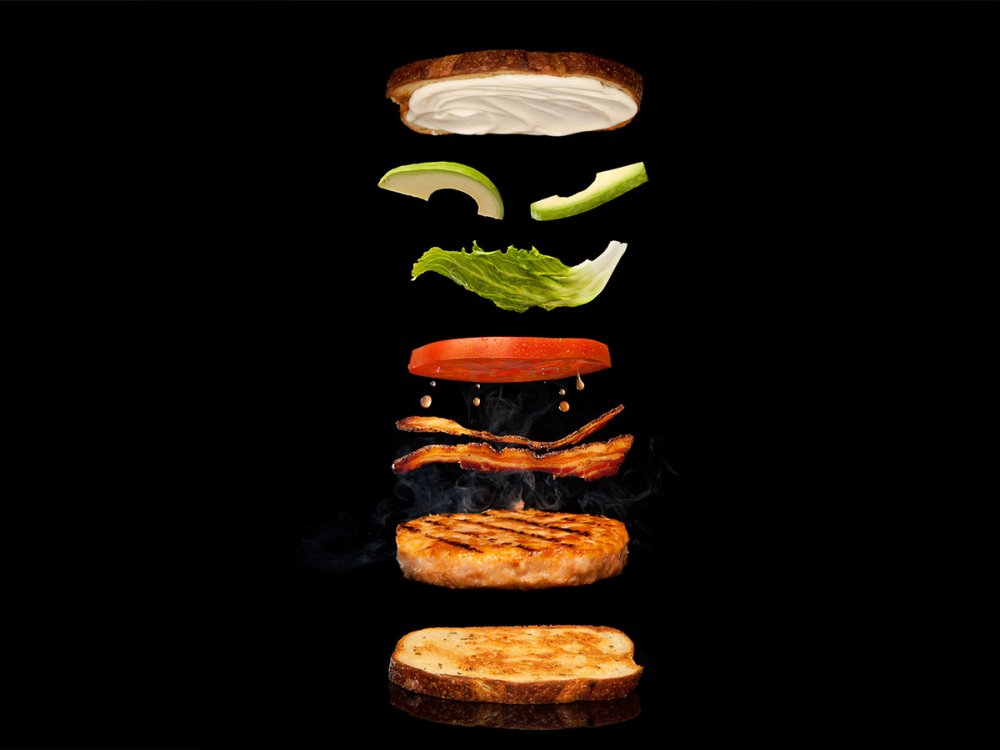 Бургер в полете на черном фоне