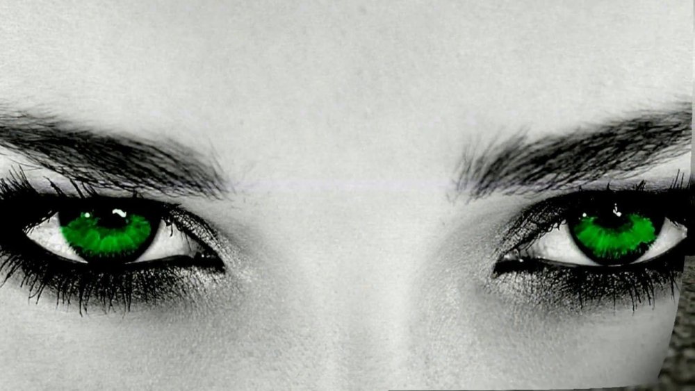 Зеленые глаза на темном фоне