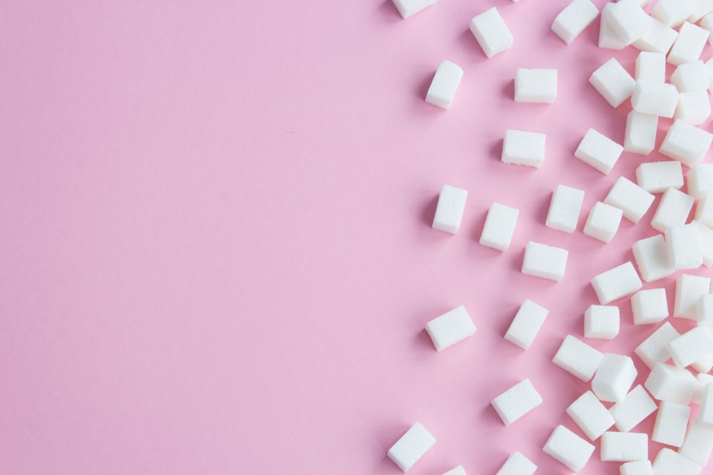 Сахар на розовом фоне