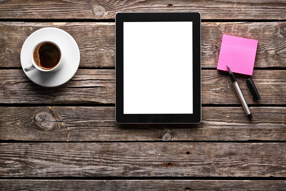 Планшет на деревянном столе