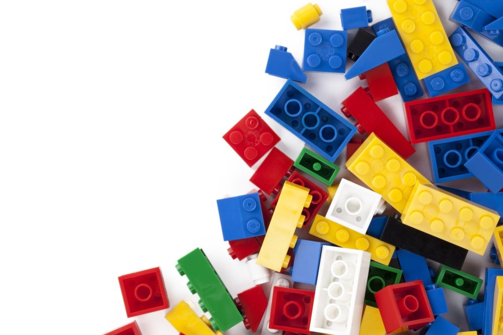 Разбросанные кирпичики лего на белом фоне