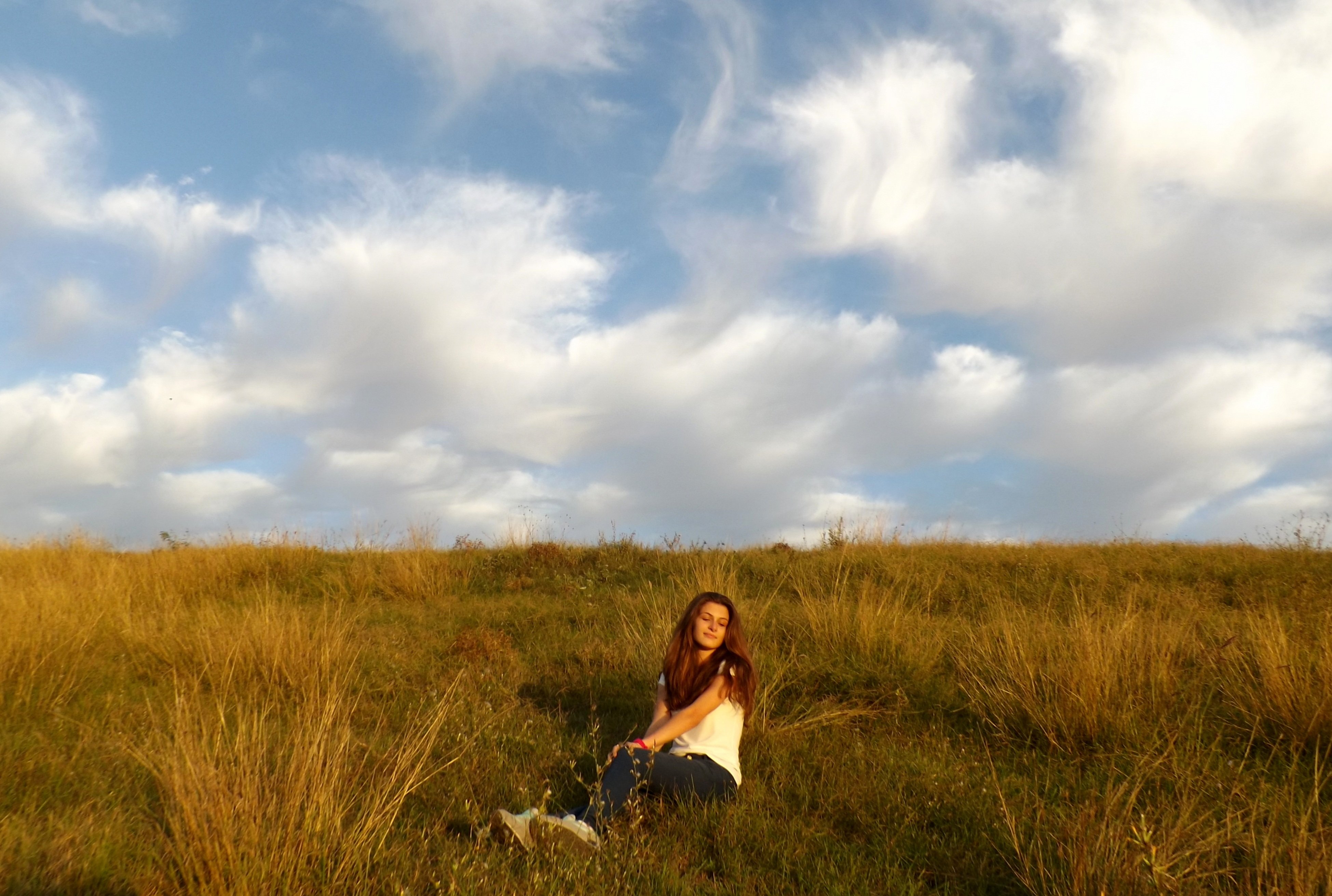 В далеке видны. Девушка в поле. Фотосессия в поле. Девушка вдалеке. Девушка на фоне неба.
