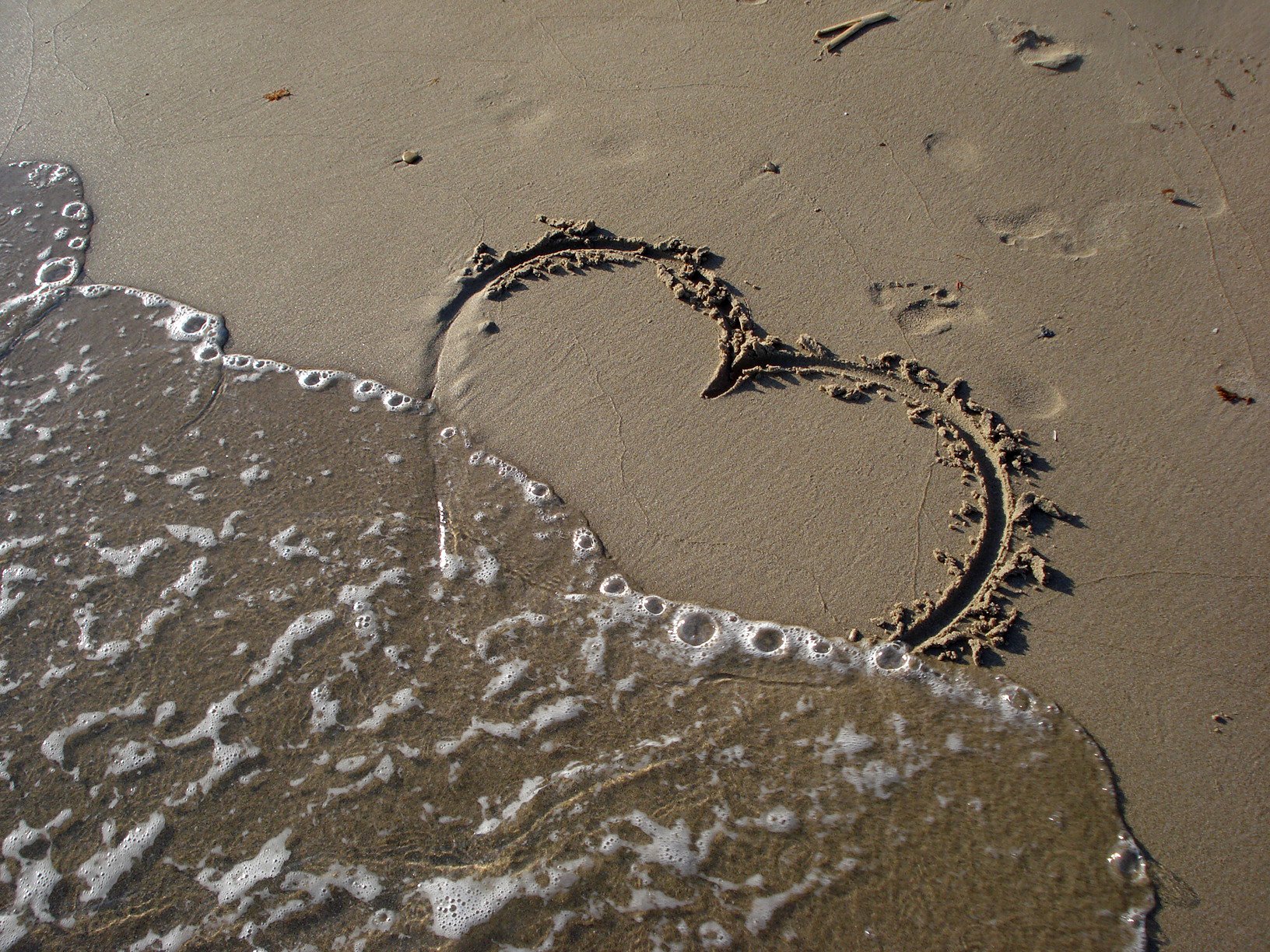 Сердечко на песке. Следы на песке. Сердечко нарисованное на песке. Следы на песке у моря. След на воде текст