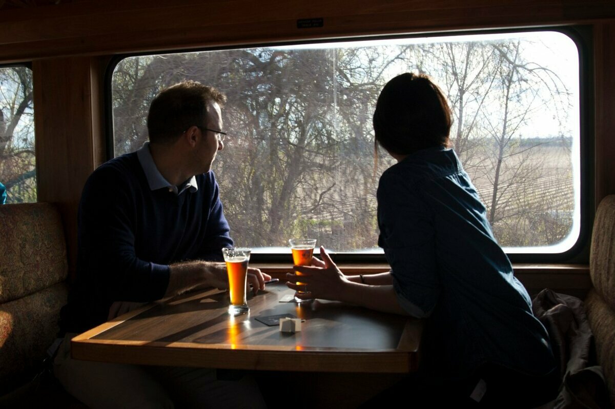 Наш полупустой поезд остановился. Мужчина и женщина в поезде. Человек в поезде у окна. Мужчина и женщина в электричке. Влюбленные в поезде.