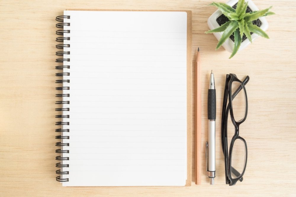 Открытый блокнот с ручкой на столе