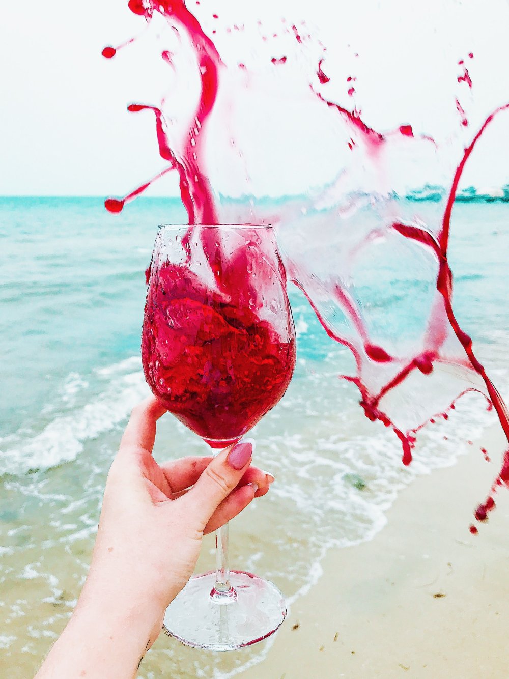 Бокал розового вина в руке