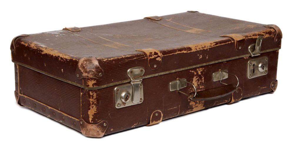 Чемодан на фоне стены