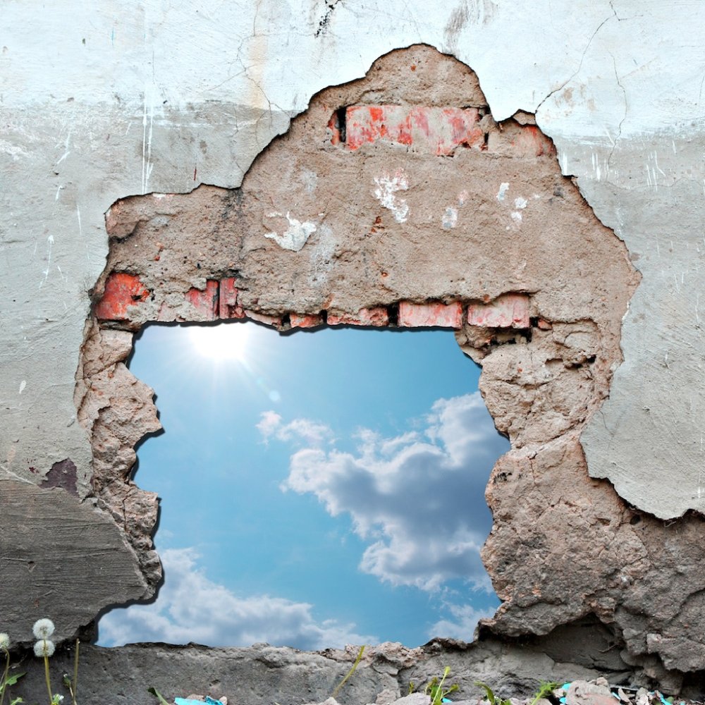 Белая кирпичная стена с дыркой