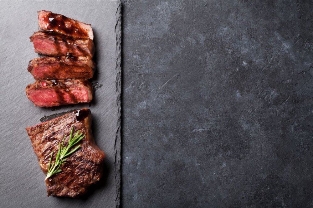 Стейк на черном фоне вид сверху