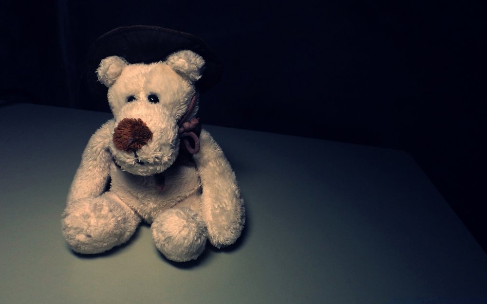 Плюшевый медведь на черном фоне