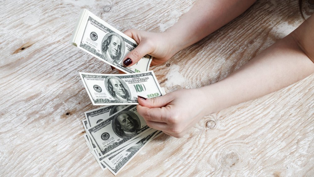 Деньги доллары в женской руке