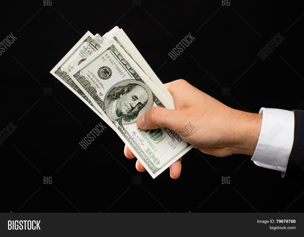 Рука с деньгами на черном фоне