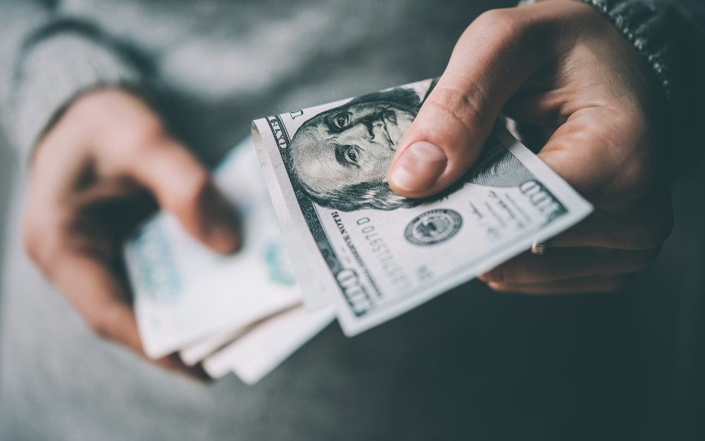 СТО долларов в руке