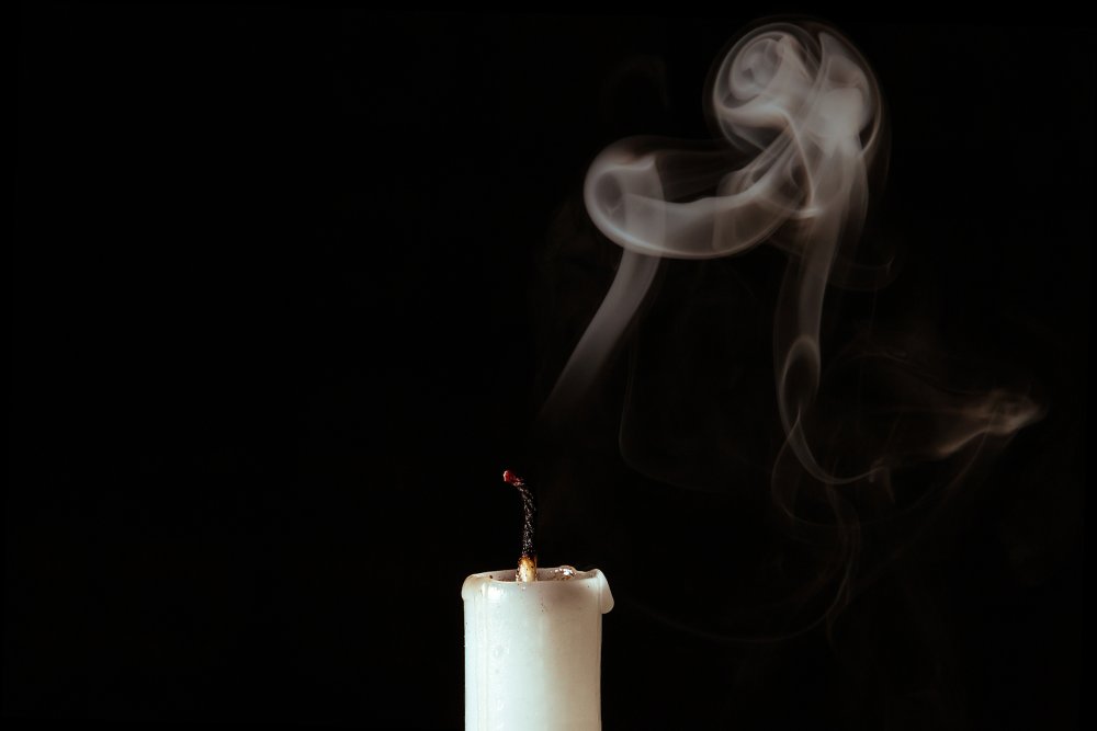 Потухшая свеча на черном фоне