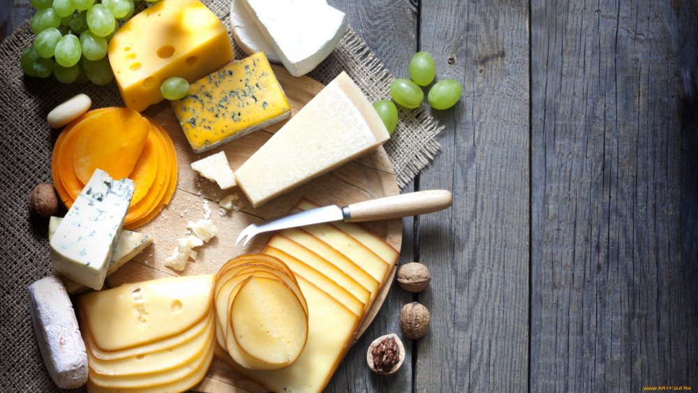 Сыр. Сыр на деревянном фоне. Сыр на столе. Сыры на доске. Сырые продукты без масла