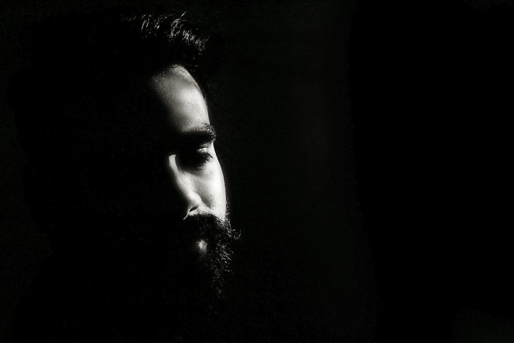 Мужчина с бородой на темном фоне