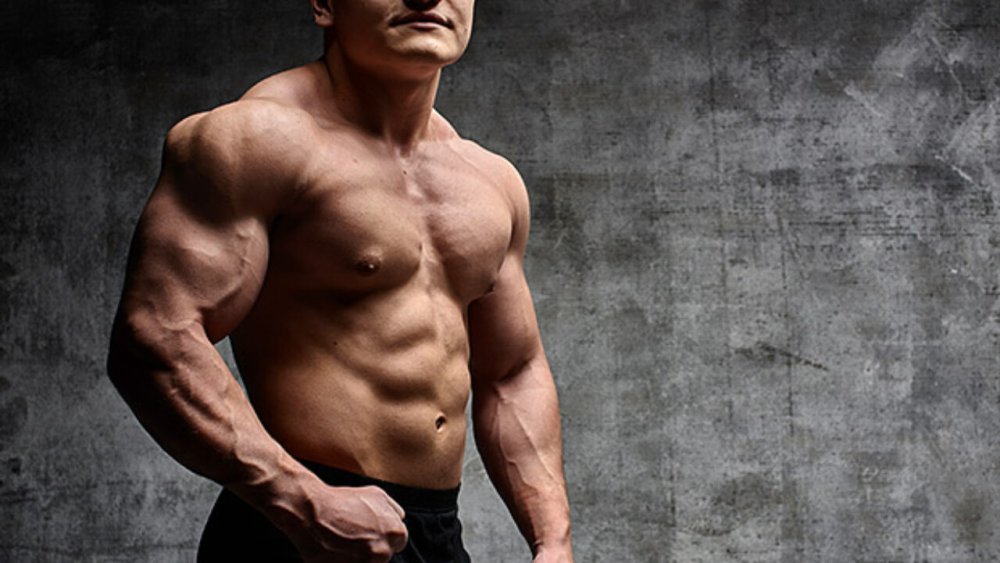 Накаченный мужчина на фоне коттеджа