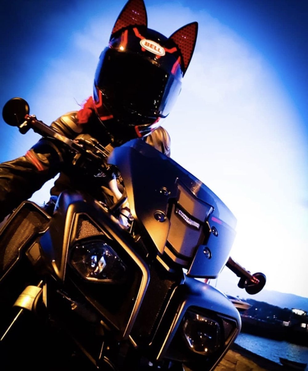 Девушка на мотоцикле в шлеме с ушками