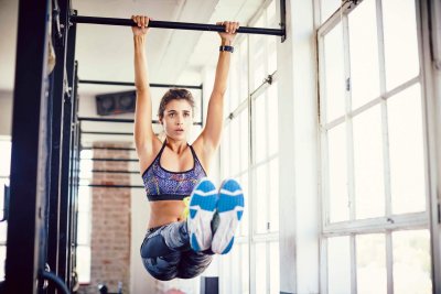 Девушка подтягивается на турнике